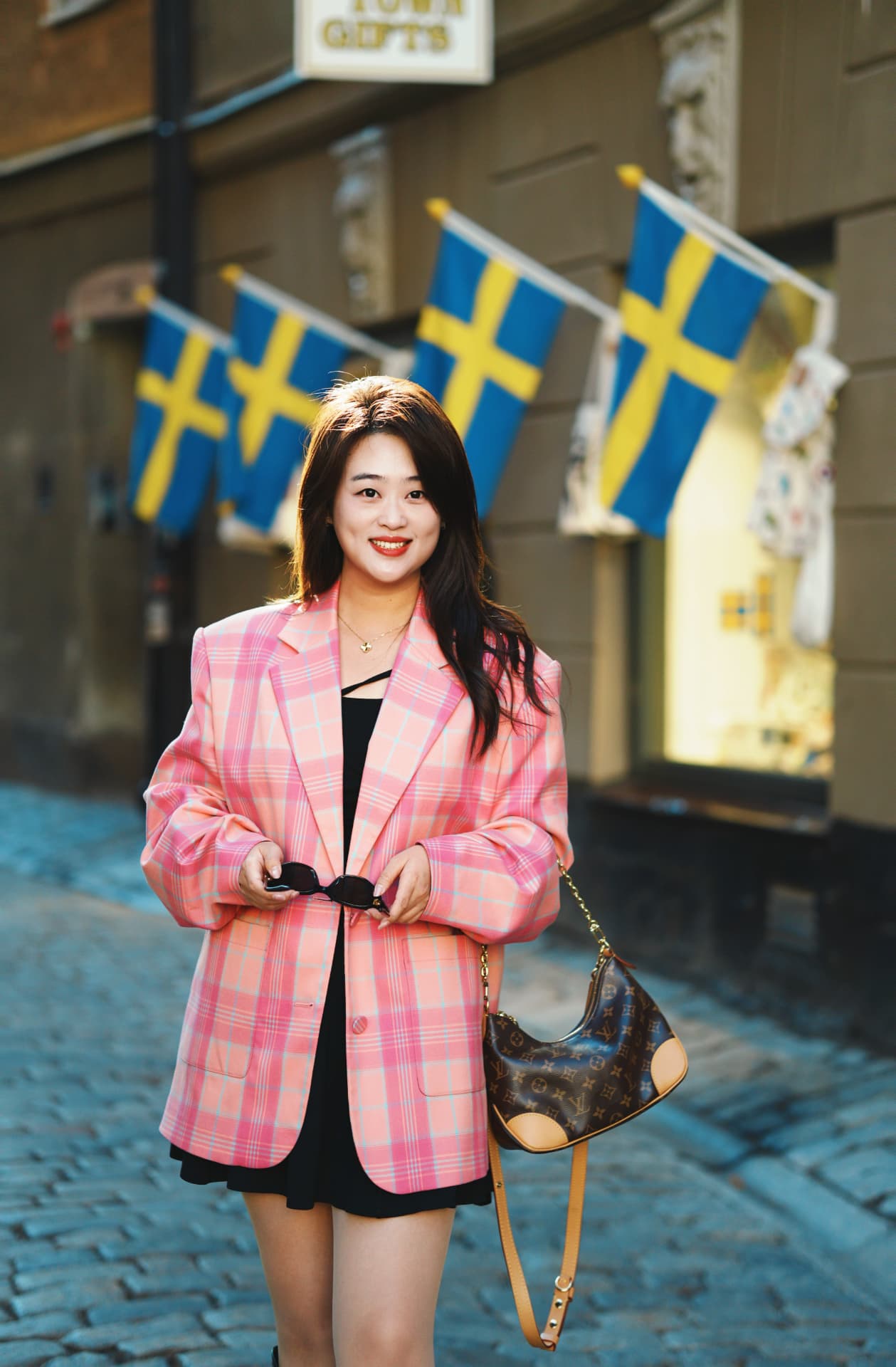 Sightseeing portrait beneath Swedish flags in Stockholm